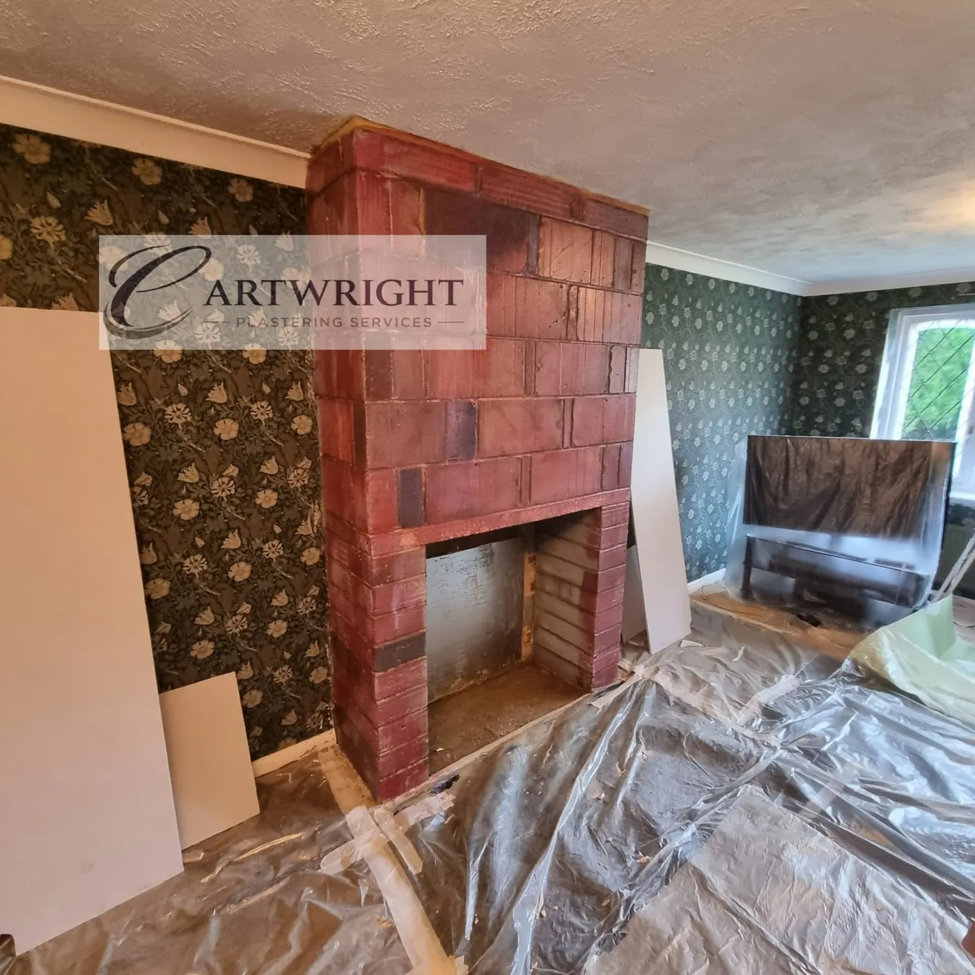 Before: bare brick chimney breast with room protected by dust sheets