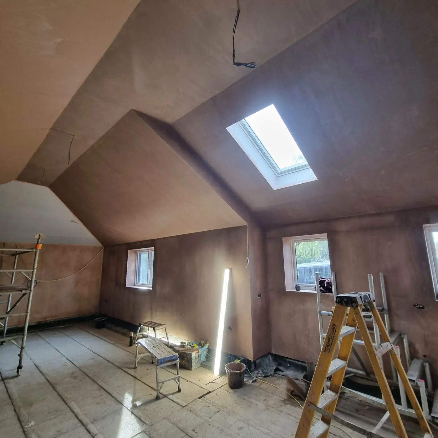 Sloped loft ceiling plastered with a roof window